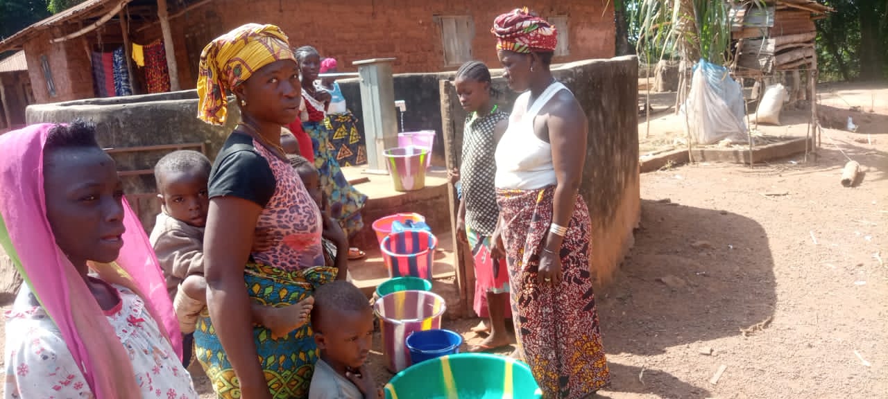 Women collecting water from a community hand pump